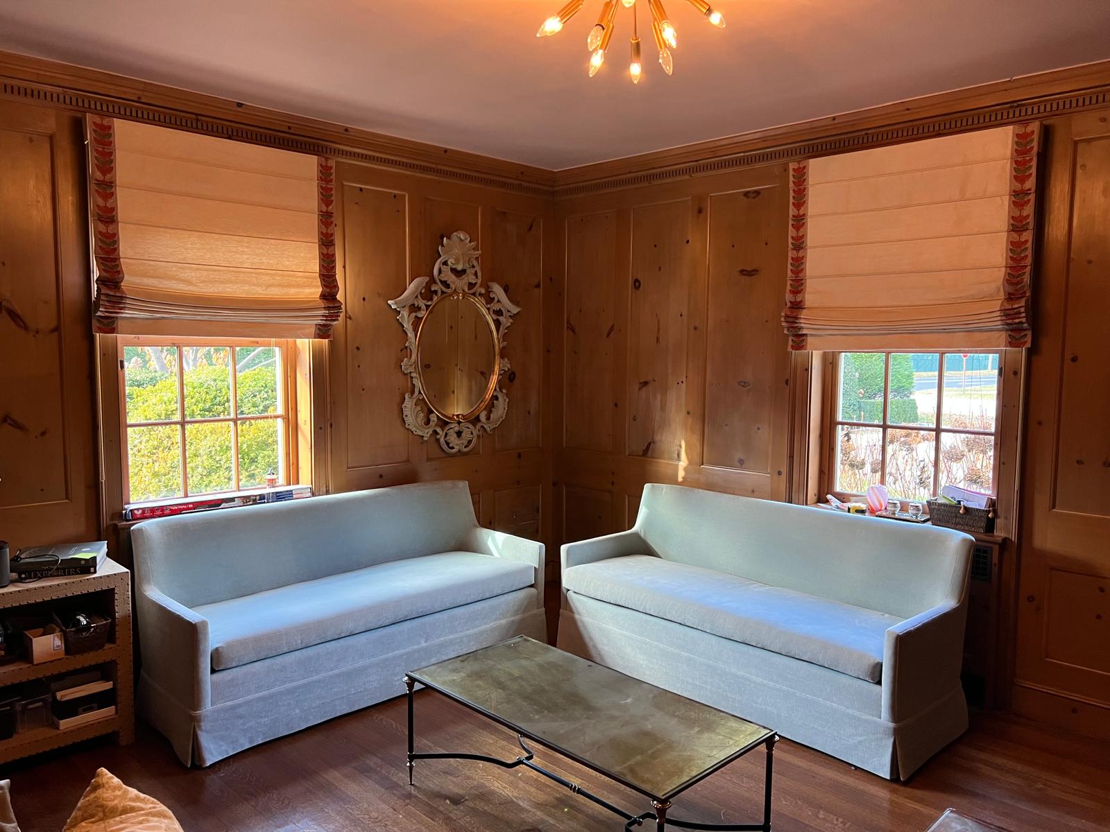Two matching sofas in wood paneled room