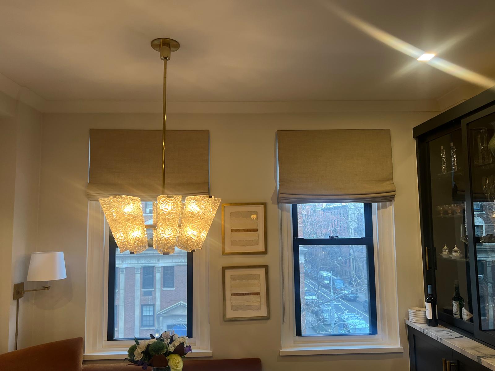 Linen roman shades in dining room with chandelier