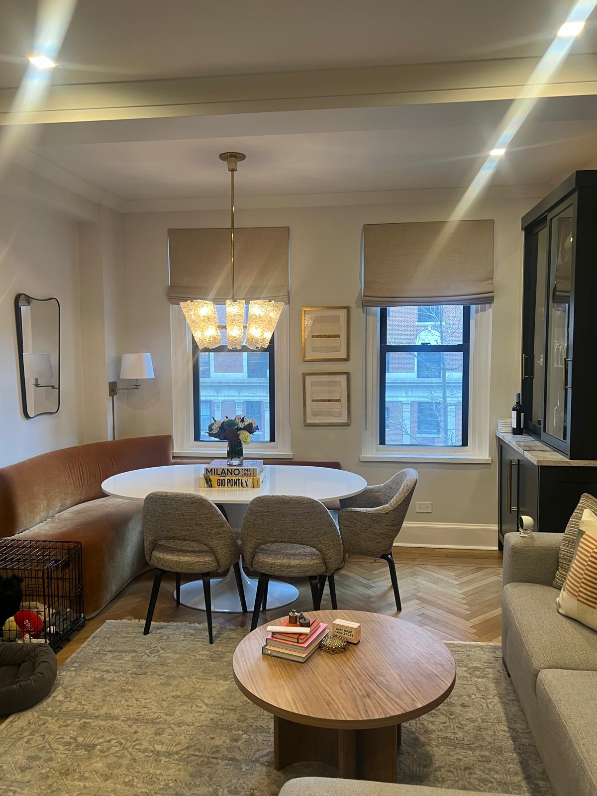 Roman shades in dining area with curved banquette sofa