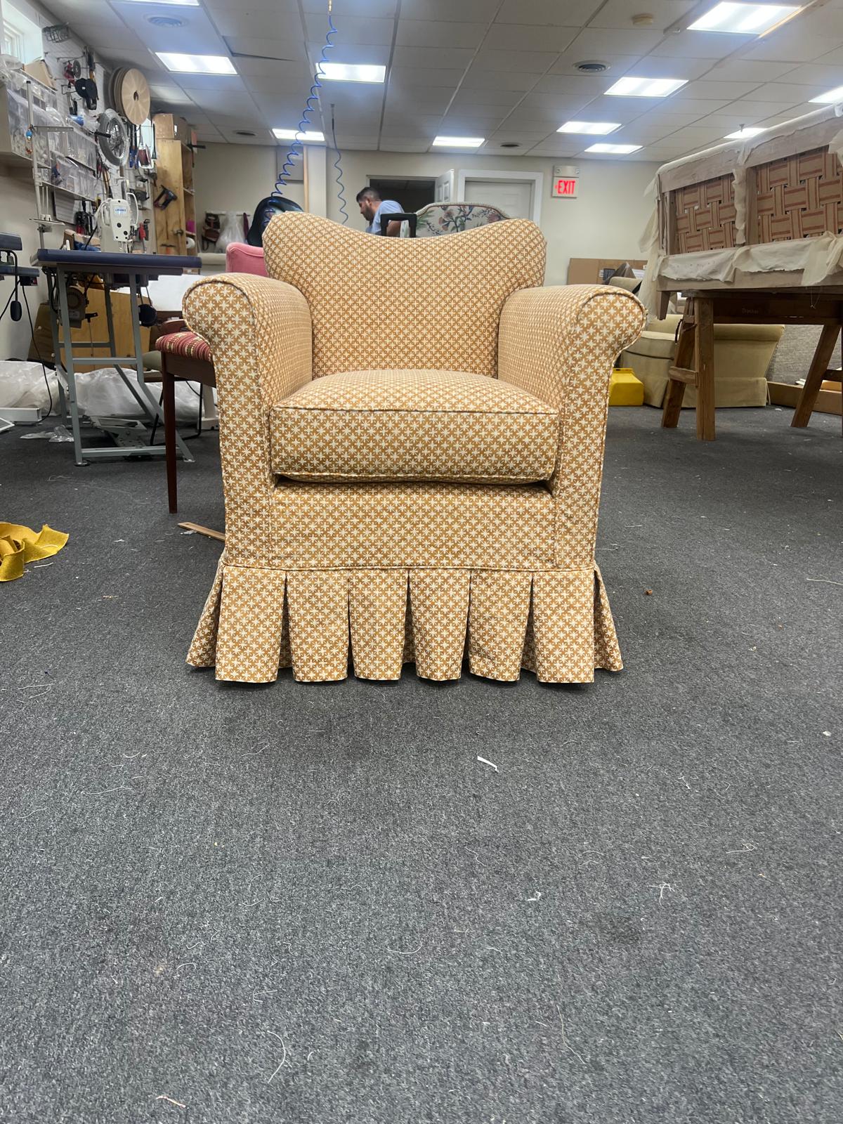 Gold club chair with pleated skirt in workshop