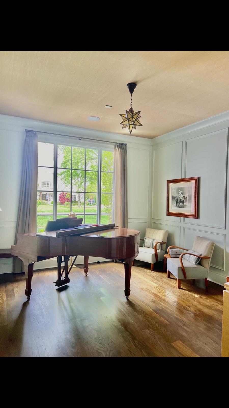 Sage green arm chairs in piano room