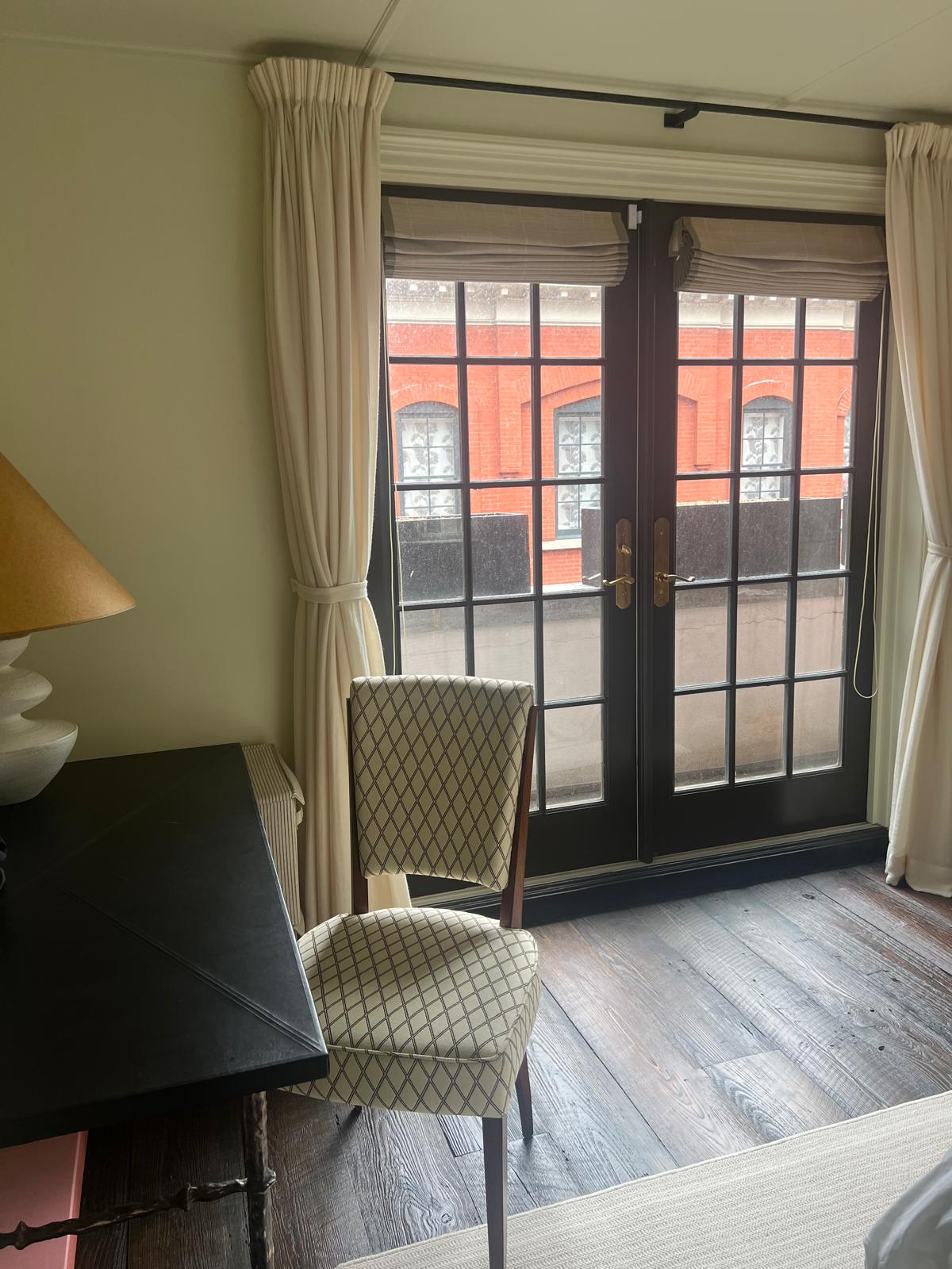 Diamond-pattern chair at French doors with drapes