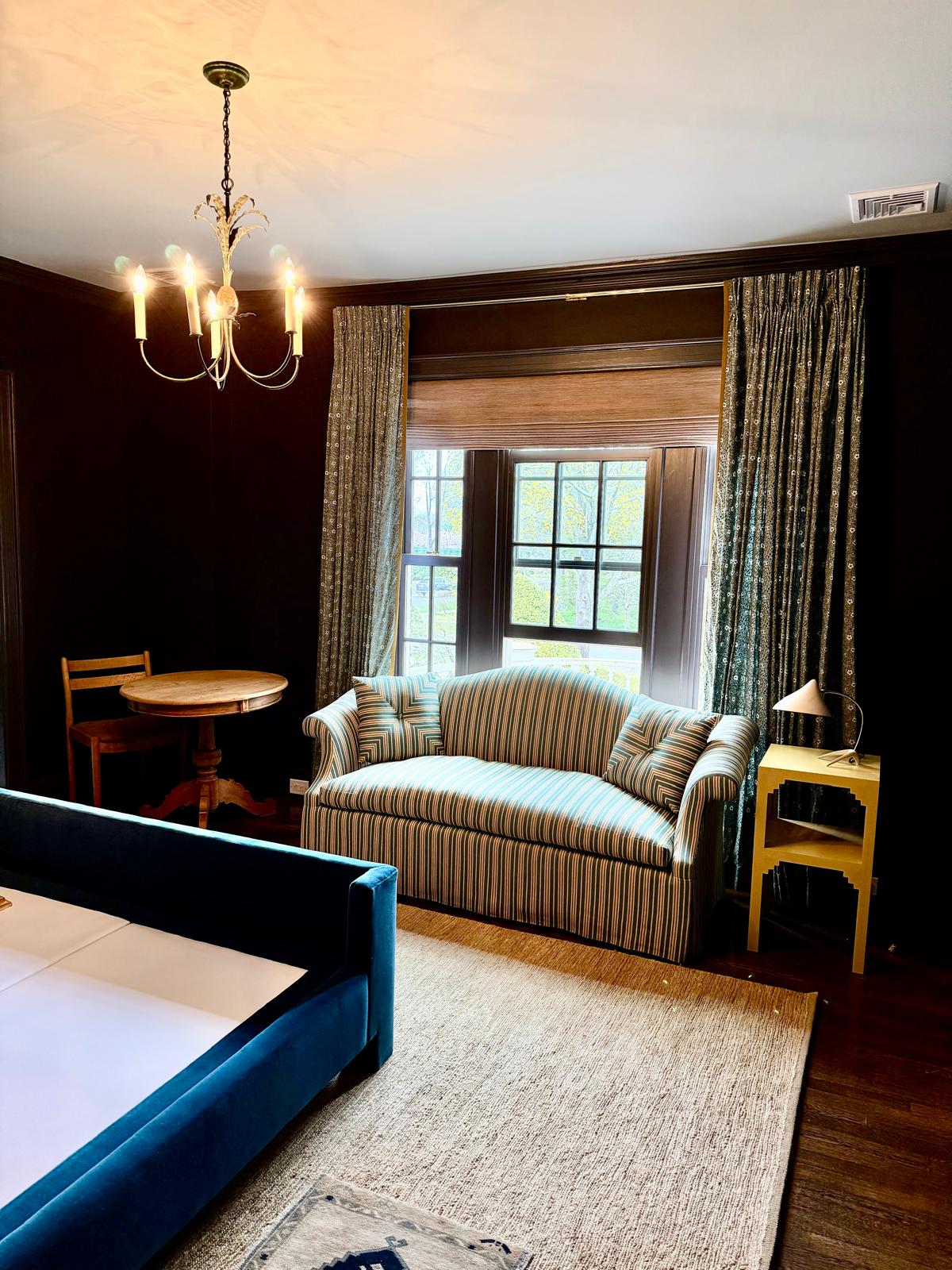 Striped loveseat in dark wood bedroom