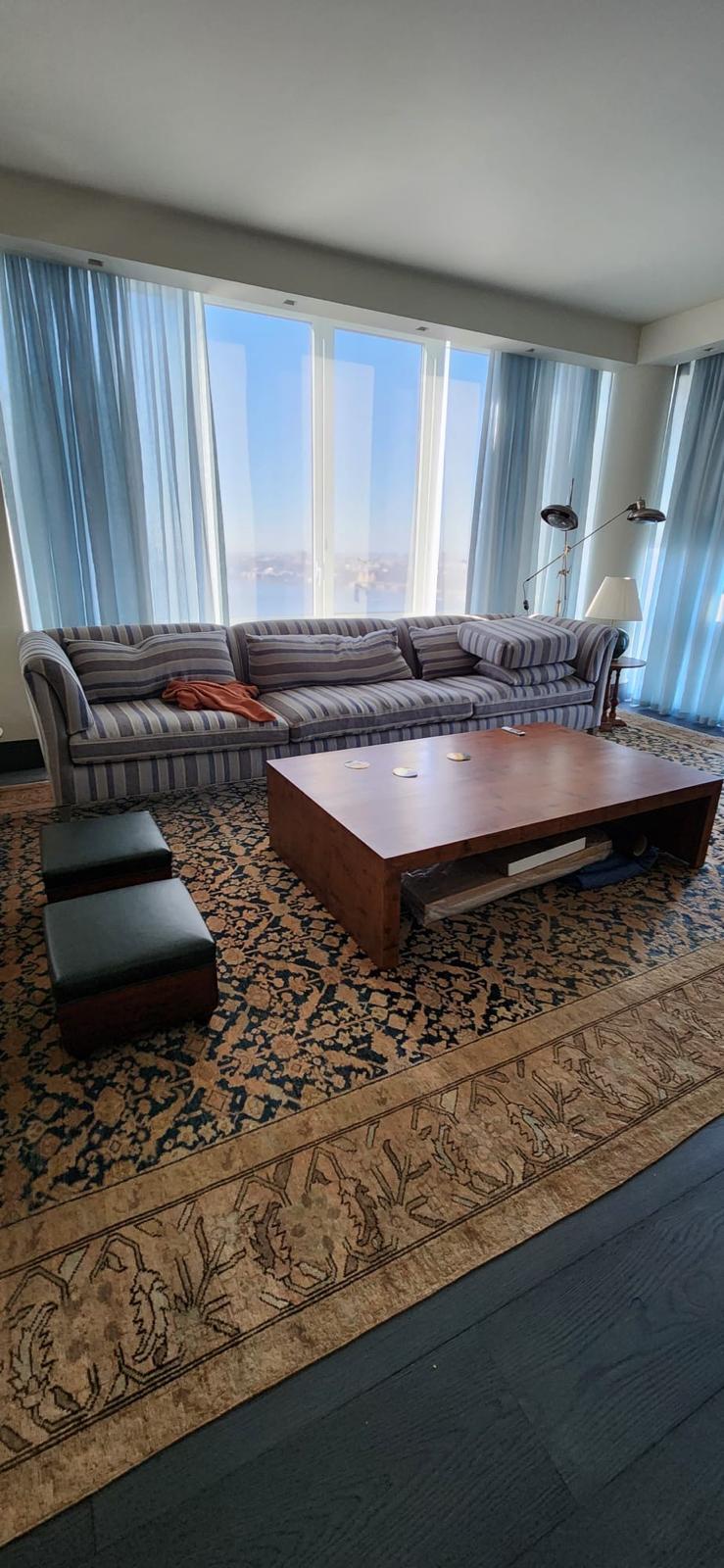 Striped sofa with NYC skyline view through floor-to-ceiling windows