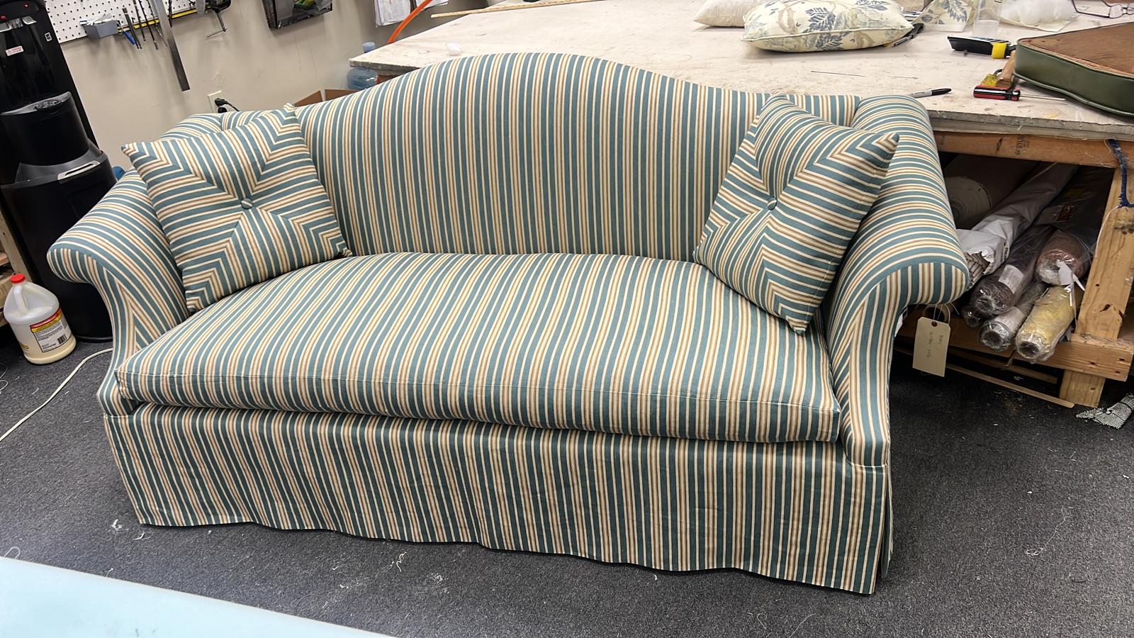 Striped camelback loveseat in workshop
