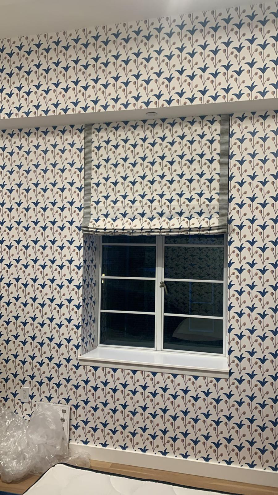 Roman shade coordinated with blue floral wallpaper