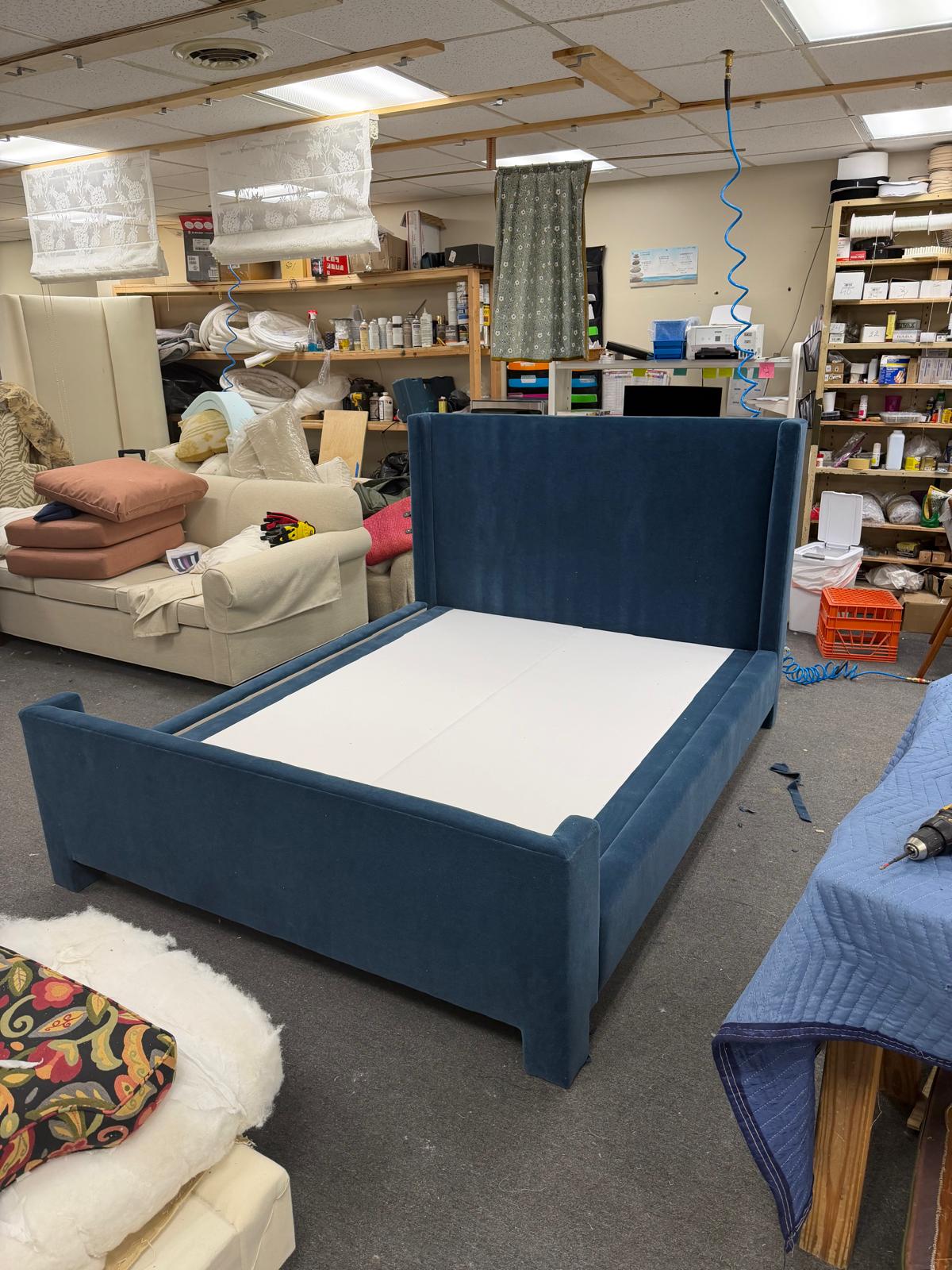 Blue velvet upholstered bed frame in workshop
