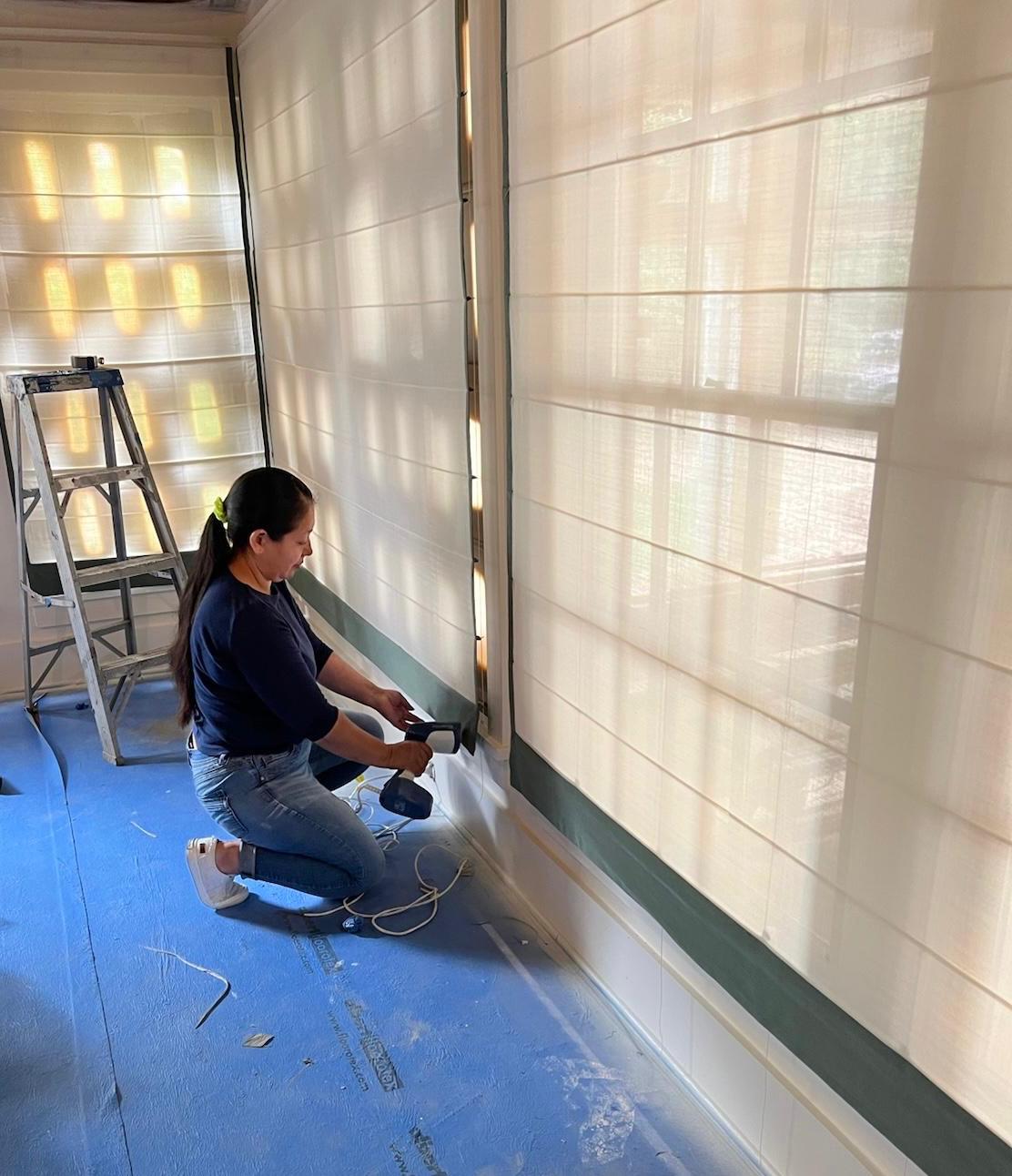 Craftsperson installing roman shades on site